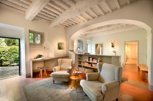a living room with two chairs and a table at Casolese di Vignamaggio in Greve in Chianti