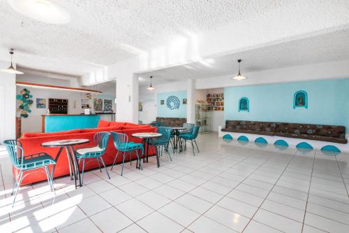 ein Restaurant mit roten und blauen Stühlen und Tischen in der Unterkunft Poseidon Blue Gastronomy Hotel in Afiartis