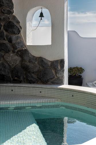 a swimming pool in a house with a stone wall at Athermi Suites - Adults Only in Megalokhori
