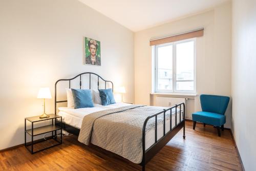 - une chambre avec un lit et une chaise bleue dans l'établissement Old Town - Vaike Karja Apartment, à Tallinn