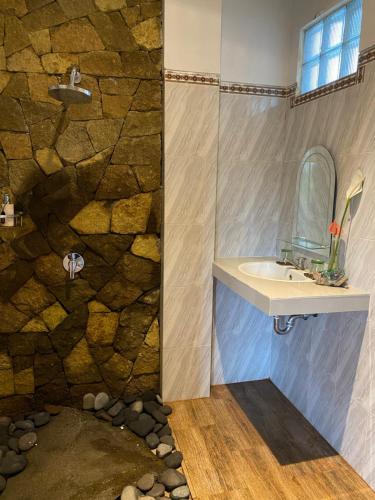 a bathroom with a sink and a shower at Budi House Bungalows in Ubud