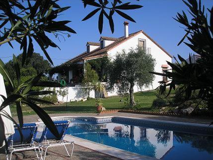 a house with a swimming pool in front of a house at Casa Rural "El Carrasca" in El Carrascalejo