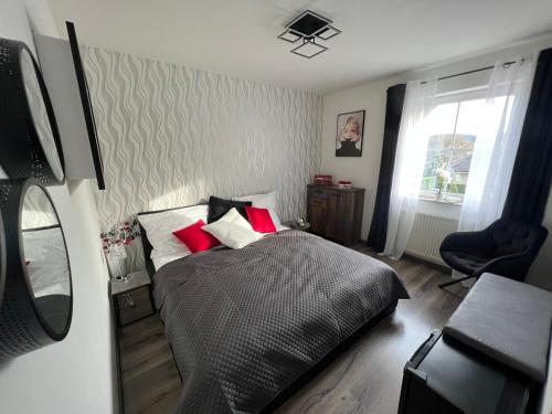 Un dormitorio con una cama con almohadas rojas y una ventana en Restaurace Pyramida en Karlovy Vary