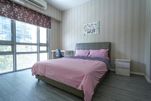 Schlafzimmer mit einem Bett mit rosa Bettwäsche und einem Stuhl in der Unterkunft GT2@Cascades Residency in Petaling Jaya