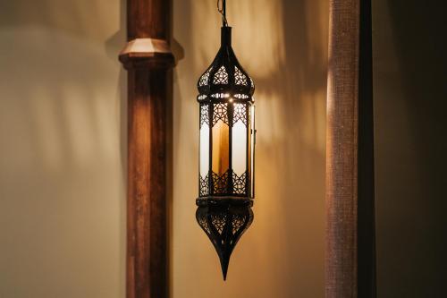 a lamp hanging from a wall next to a pole at Emotional Grand Motel in Fontaneto dʼAgogna