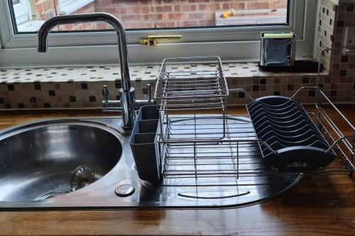 a kitchen sink with a dish drying rack next to it at Gorgeous 2 bedroom Kintbury cottage in Kintbury