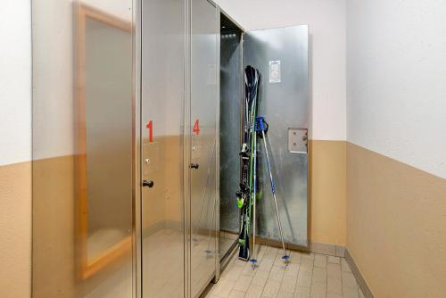 a glass shower in a room with skis in it at Chalet Sonne Apt Grande in Livigno