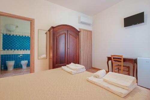 a bedroom with a bed with two towels on it at La Scala del Sale in Iglesias