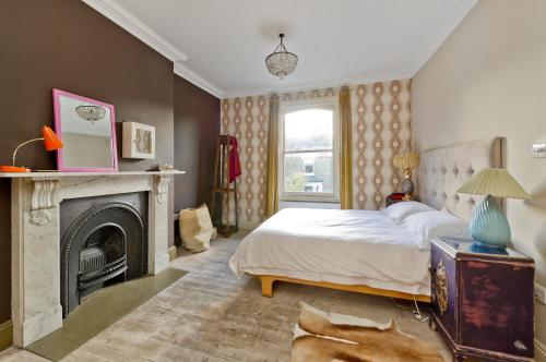 1 dormitorio con 1 cama y chimenea en Veeve - The Artist's House en Londres