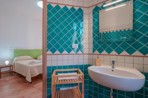 W łazience znajduje się umywalka i lustro. w obiekcie La Scala del Sale w mieście Iglesias