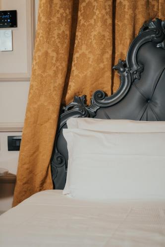 a bed with a black headboard with a white pillow at Emotional Grand Motel in Fontaneto dʼAgogna