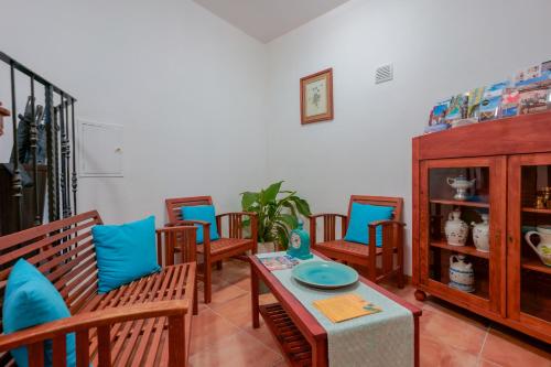 a living room with wooden chairs and a table at La Scala del Sale in Iglesias