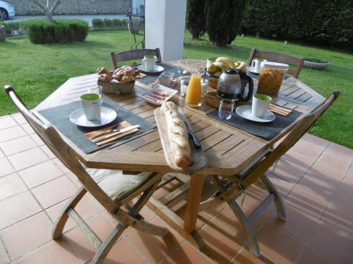 a wooden table with food on it on a patio at Les chambres d'hôtes d'Eloïse, piscine privée in Aramon