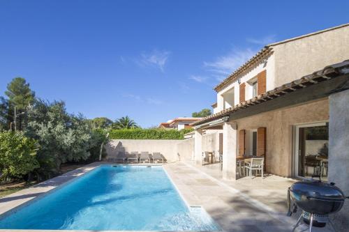 une villa avec une piscine à côté d'une maison dans l'établissement Maison Esterel in Saint-Raphael, à Saint-Raphaël