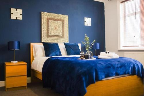 a blue bedroom with a bed with a blue blanket at Beautiful Large 4 Bedrooms house in central Southampton in Southampton