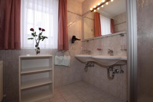 La salle de bains est pourvue d'un lavabo et d'un miroir. dans l'établissement Bella Vista Active Apart, à Nauders