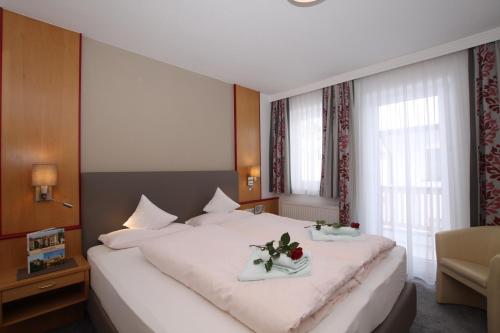 a bedroom with a large white bed with flowers on it at Bella Vista Apartments in Nauders