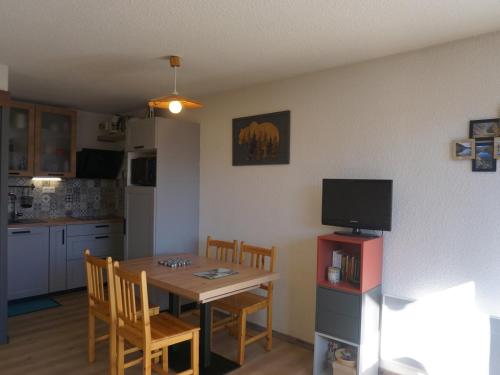 une cuisine et une salle à manger avec une table et une télévision dans l'établissement Studio cabine ensoleillé pour 4 pers. proche pistes, animaux acceptés - FR-1-636-129, à Orcières