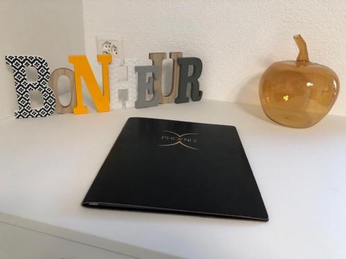 a laptop on a white counter with a vase and letters at Plein coeur de Nendaz in Nendaz