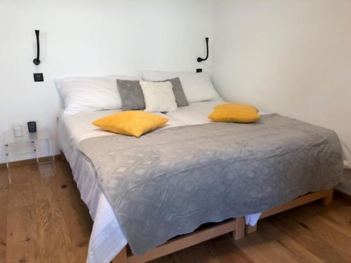 een bed met twee kussens in een kamer bij Plein coeur de Nendaz in Nendaz