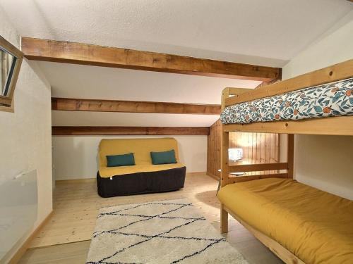 une chambre avec deux lits superposés et un tapis dans l'établissement Duplex rénové 6 personnes avec balcon, à Plagne 1800 - FR-1-455-224, à La Plagne Tarentaise