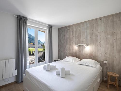 um quarto com uma grande cama branca e uma janela em Appartement Chamonix-Mont-Blanc, 2 pièces, 4 personnes - FR-1-343-230 em Chamonix-Mont-Blanc