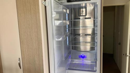 an empty refrigerator with its door open in a room at 3 Bedrooms Loch Views Heated Pool Close To Beaches in Newton Stewart