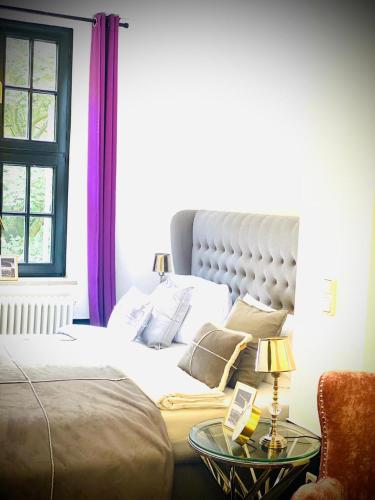 - une chambre avec un lit et une table avec une lampe dans l'établissement Sleephotels Suite Garde, à Hambourg