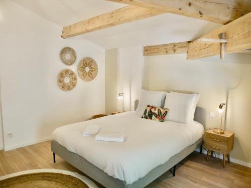 Schlafzimmer mit einem großen weißen Bett und Holzdecken in der Unterkunft Callelongue-Coliving-Mas des Sous Bois in Ventabren