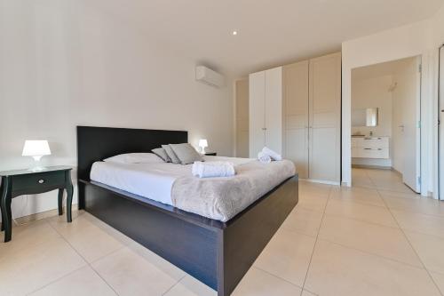 a bedroom with a large bed and a table at Villa Terrasse et Piscine à l'entrée de Porticcio in Cauro