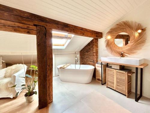 La salle de bains est pourvue d'une baignoire et d'un lavabo. dans l'établissement Les Puits Clos : magnifique T2 sous les toits, à Toulouse