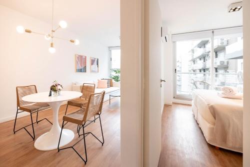 Habitación blanca con mesa, sillas y cama en Top Rentals Palermo Hollywood en Buenos Aires