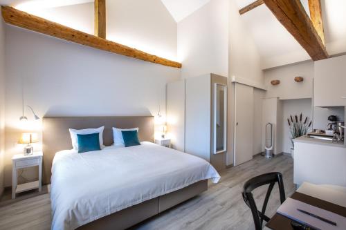 a bedroom with a large bed with blue pillows at Auberge des Grands Bois in Buchillon