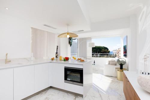 une cuisine blanche avec des comptoirs blancs et une cheminée dans l'établissement Les Légendes YourHostHelper, à Cannes