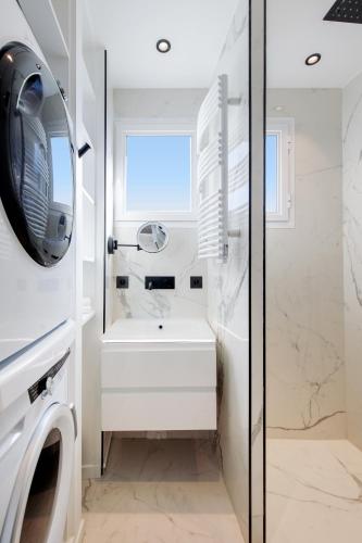 une salle de bain avec un lavabo et une machine à laver dans l'établissement Les Légendes YourHostHelper, à Cannes