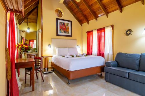 um quarto com uma cama, uma secretária e um sofá em Cahal Pech Village Resort em San Ignacio