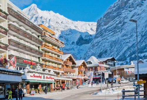 a street in a town with mountains in the background at Hotel Bernerhof Grindelwald in Grindelwald