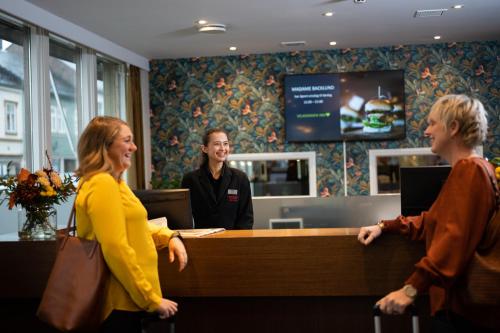 a group of people standing around a reception desk at Thon PartnerHotel Backlund in Levanger