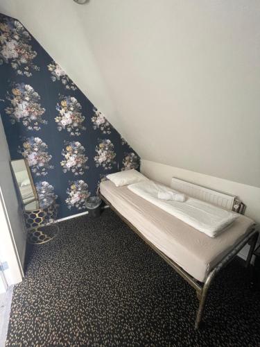 Kleines Zimmer mit einem Bett mit blauer Wand in der Unterkunft Thuis bij Schell in Rotterdam