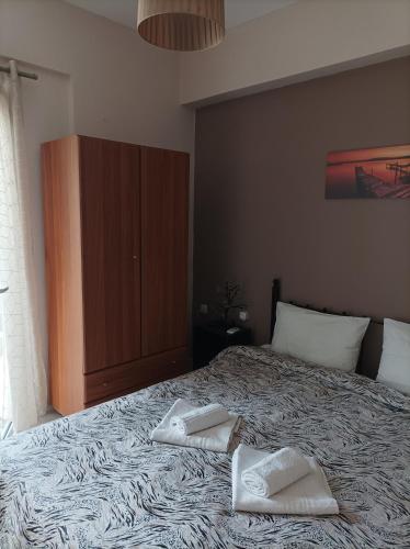 a bedroom with a bed with two towels on it at Eirini's Apartment in Missolonghi