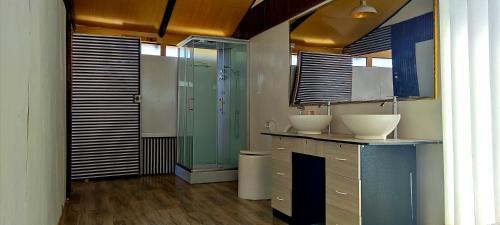 a bathroom with two sinks and a glass shower at Titicaca Habitación Vista al lago in Puno