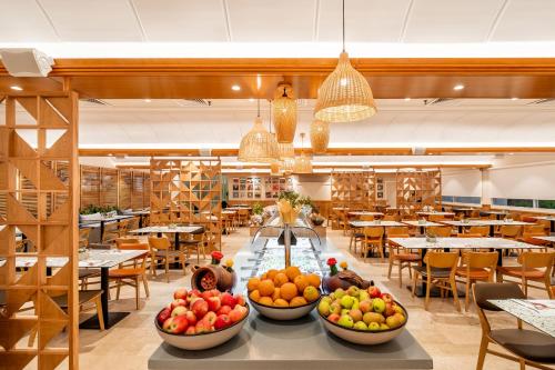فندق برايما ميوزيك في إيلات: غرفة طعام مع أطباق من الفواكه على طاولة