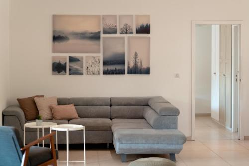 a living room with a couch and some pictures on the wall at Villa Terrasse et Piscine à l'entrée de Porticcio in Cauro