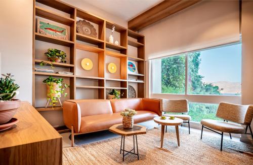 a living room with a couch and chairs and a large window at Prima Music Hotel in Eilat
