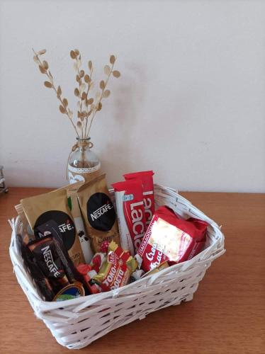 a basket filled with snacks on a table with a vase at Eirini's Apartment in Missolonghi
