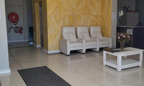 a living room with a couch and a table at SHALIMAR GARDENS HOTEL in Cape Town