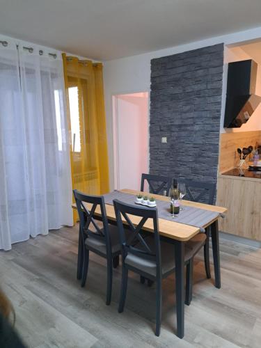 a dining room with a wooden table and chairs at Apartman Stefany in Varaždin