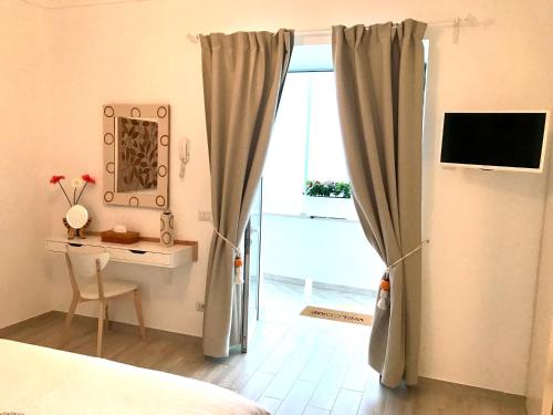 a bedroom with a bed and a desk and a window at Suite Casalbivio in Positano