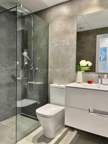 a bathroom with a shower and a toilet and a sink at Sea Hills semidetached Luxury Villa in Finestrat