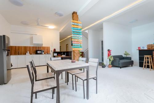 a kitchen and dining room with a table and chairs at Violet Inn Hotel in Dharavandhoo